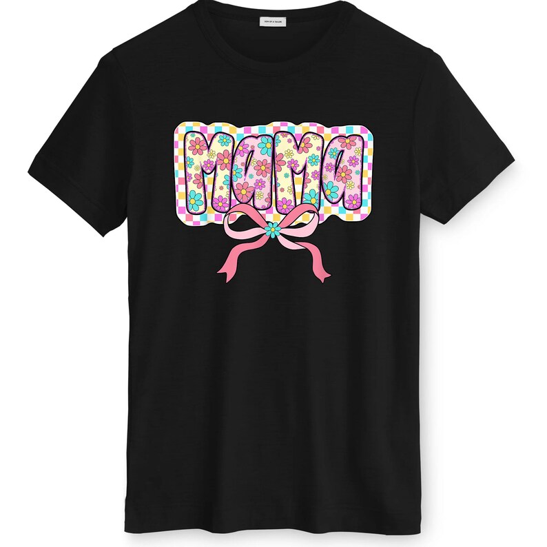 May include: Black t-shirt with the word "MAMA" in a colourful, floral design. The word is in a bubble letter style with a pink bow. The shirt is a classic crew neck style, suitable for casual wear.