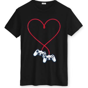 May include: Black t-shirt featuring a red heart design with two white game controllers at the bottom. The controllers are connected to the heart by a red line, creating a unique graphic.