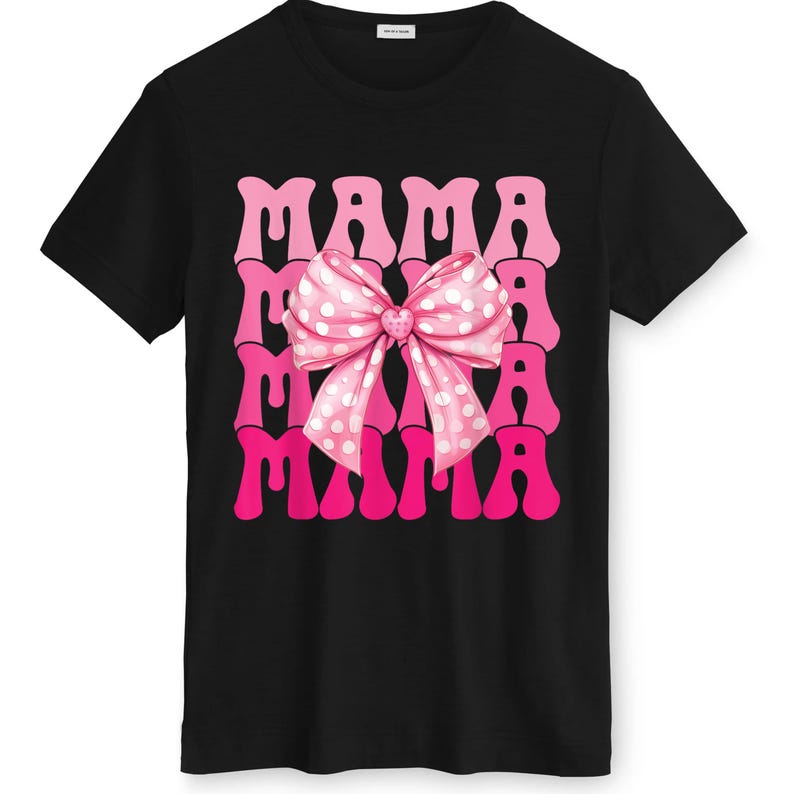 May include: Black t-shirt featuring the word "MAMA" in pink, repeated three times. A pink bow with white polka dots is centered on the design. The shirt has a crew neck and short sleeves.