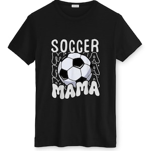 May include: Black t-shirt with a white and black soccer ball graphic. The words "SOCCER MAMA" are printed in white above and below the soccer ball. The design has a retro, wavy font.