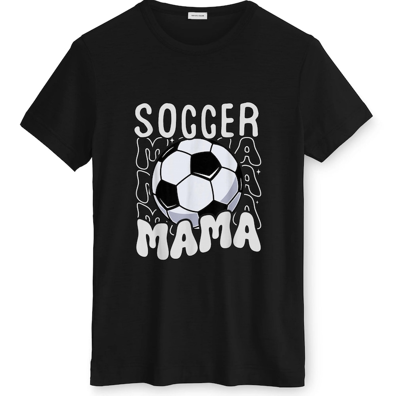 May include: Black t-shirt with a white and black soccer ball graphic. The words "SOCCER MAMA" are printed in white above and below the soccer ball. The design has a retro, wavy font.
