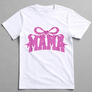 May include: White t-shirt with the word "MAMA" in a pink leopard print font, and a matching bow design. The t-shirt has a crew neck, suitable for everyday wear.