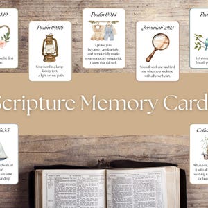 May include: A collection of Scripture Memory Cards with watercolor illustrations and Bible verses. The cards feature images of a heart, lantern, clothing, a magnifying glass, birds, a sailboat, and a fence. The words "Scripture Memory Cards" are displayed.