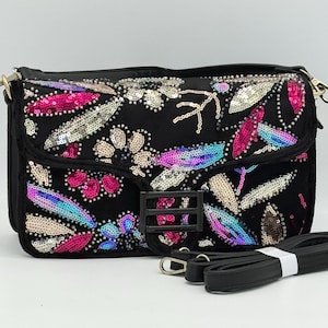 May include: Black shoulder bag with a flap closure, decorated with colourful sequins in a floral design. The bag has a black adjustable strap and a metal buckle. The sequins are in shades of pink, blue, and silver.