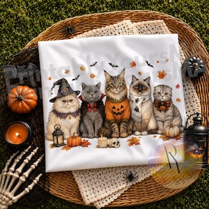 May include: A white t-shirt featuring a graphic of five cats dressed in Halloween costumes, including a witch hat, vampire cape, pumpkin sweater, ghost scarf, and plaid bowtie, surrounded by autumn leaves, bats, and small pumpkins.