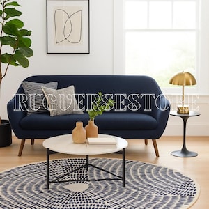 Puede incluir: Un salón moderno con un sofá azul marino, una mesa de centro redonda con tapa de mármol blanco y una alfombra estampada. Una lámpara dorada descansa sobre una mesa auxiliar negra. Jarrones decorativos y cojines completan la habitación.