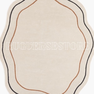 May include: A cream-coloured, wavy-edged rug with a minimalist design. It features two concentric lines: a dark brown outer line and a lighter brown inner line. The text "RUGVERSESSTORE" is printed in white across the rug.