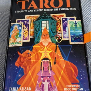 May include: A tarot card deck box with the title "THE ALEISTER CROWLEY TAROT" in orange letters. The box features illustrations of tarot cards and figures in orange, purple, and blue. The text "THOUGHTS AND VISIONS BEHIND THE FAMOUS DECK" is also visible.