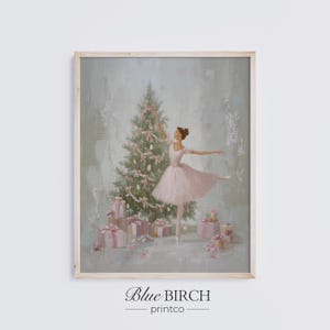 May include: A framed print featuring a ballerina in a pink tutu, dancing near a decorated Christmas tree. The artwork has a soft, pastel color palette with pink and green accents. Gift boxes are at the base of the tree. The print is from Blue Birch printco.