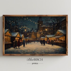 May include: A framed print of a winter market scene at night. The artwork depicts a snowy street with market stalls illuminated by warm lights. People are strolling through the market. The frame is made of wood. The text "BlueBIRCH printco" is at the bottom.