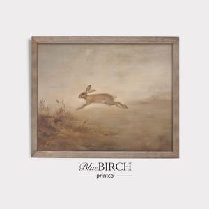 May include: A framed vintage-style print featuring a running hare in a field. The artwork has a muted color palette of browns and tans, with the hare in mid-leap. The print is in a wooden frame, and the text "BlueBIRCH printco" is at the bottom.
