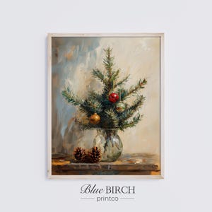 May include: A framed painting of a small Christmas tree in a glass vase, adorned with ornaments. Two pine cones sit below the vase on a wooden surface. The painting has a soft, impressionistic style with a neutral background.