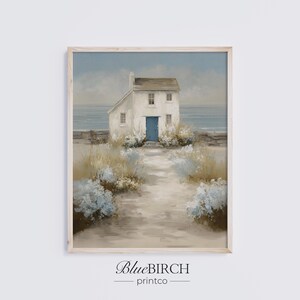 Puede incluir: Impresión artística enmarcada de una escena costera. Una casa blanca con una puerta azul se encuentra cerca del mar, con un camino que conduce a ella. La obra de arte presenta tonos apagados de azul, beige y blanco, con el texto "BlueBIRCH printco" en la parte inferior.