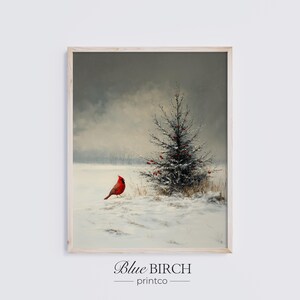 May include: Framed winter landscape print featuring a red cardinal bird perched in a snowy field near a small evergreen tree. The artwork has a muted color palette with a cloudy sky. The text "Blue Birch printco" is at the bottom.
