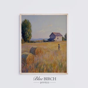 Op de afbeelding: Ingelijste landschapskunstafdruk met een landelijke scène met hooibalen, een boerderij en een figuur in een veld. Het kunstwerk heeft een warm kleurenpalet met tinten geel, bruin en blauw. De print is van Blue Birch printco.