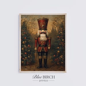May include: A framed print featuring a detailed illustration of a nutcracker soldier in a red uniform with a tall hat and white beard. The background shows Christmas trees and a forest scene. The print has the text "Blue Birch printco" at the bottom.