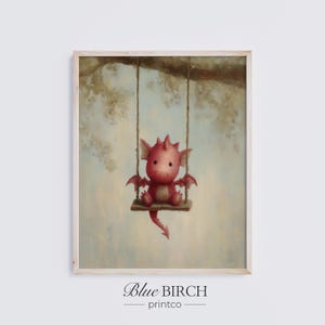 May include: A framed print showing a red dragon on a swing. The dragon has small wings and is suspended from a tree branch. The print has a soft, pastel colour palette and the text "Blue BIRCH printco" at the bottom.