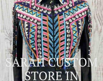Pode incluir: Camisa de show preta com intrincados trabalhos de contas em rosa, azul, laranja e prata. O design apresenta padrões geométricos e franjas. O texto "SARAH CUSTOM STORE IN" é visível.
