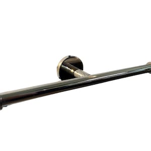 May include: A chrome toilet paper holder. It has a circular wall mount and a horizontal bar for the toilet paper roll. The bar has rounded ends. The fixture is made of shiny metal, reflecting light.