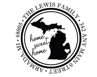 May include: Black and white round sticker with the text "THE LEWIS FAMILY" and "342 ANY MAIN STREET, ARMADA, MI 48005" around the outside. The center of the sticker features a black silhouette of the state of Michigan with a small heart in the lower right corner. The text "home sweet home" is written in cursive inside the state outline.