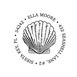 May include: A circular black ink stamp design featuring a central illustration of a fan-shaped seashell. The text ELLA MOORE, 432 SEASHELL LANE, #2, and SIESTA KEY, FL 34242 is arranged in a circular pattern around the central seashell graphic.