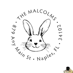 May include: A black and white return address stamp with a cute bunny rabbit illustration. The text reads "The Malcolms, 879 Any Main St., Naples, FL 34102."