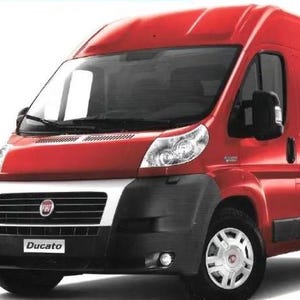 Puede incluir: Una furgoneta Fiat Ducato roja con parachoques delantero negro y detalles blancos. La furgoneta tiene una prominente parrilla delantera con el logotipo de Fiat y el nombre "Ducato". Las ruedas son plateadas.
