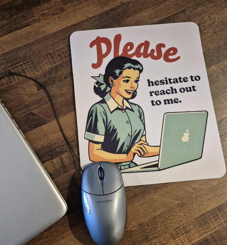 May include: A computer mouse and a mousepad featuring a retro illustration of a woman using a laptop. The mousepad has the text "Please hesitate to reach out to me" in red and black.