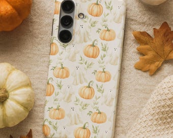 May include: A white phone case featuring a repeating pattern of orange pumpkins, friendly ghosts, and green leaves. The case has a camera module with three lenses. The design evokes a fall or Halloween theme.