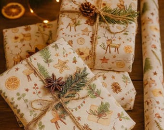 May include: Christmas-themed wrapped gifts with patterned paper featuring deer and botanical illustrations. The parcels are tied with twine and decorated with pine cones and greenery. A roll of matching wrapping paper is also present.