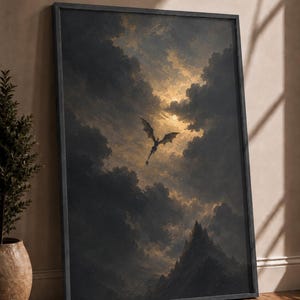May include: A framed vertical wall art print featuring a dark, winged dragon silhouette soaring through a dramatic, cloudy sky above jagged mountain peaks. The scene is illuminated by a golden light breaking through the dense, stormy clouds.