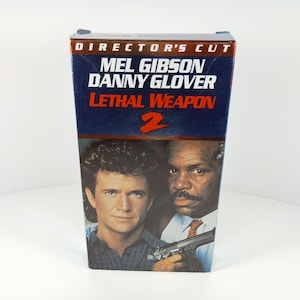 May include: A DVD case for the movie "Lethal Weapon 2" featuring Mel Gibson and Danny Glover. The case has a blue and red color scheme with the words "Director's Cut" at the top.