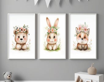 May include: Set of three framed watercolor prints featuring adorable woodland animals. The prints showcase a bear, a bunny, and a fox, each adorned with a floral crown. The artwork is set against a white background, framed in white, and perfect for a nursery.