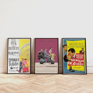 Puede incluir: Se muestran tres carteles enmarcados de la película "Vacaciones en Roma". Los carteles presentan a Gregory Peck y Audrey Hepburn. Los carteles tienen una combinación de colores amarillo, rosa y azul, con el título de la película en un lugar destacado.