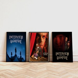Puede incluir: Tres carteles enmarcados de la película "Entrevista con el vampiro" se exhiben contra una pared blanca. Los carteles presentan imágenes oscuras y góticas con el título en una fuente estilizada. Los carteles están en marcos negros y están sobre un suelo de madera.