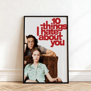 May include: A framed movie poster for "10 Things I Hate About You." The poster features two actors in a brown armchair, with the movie title in red letters. The actors are looking at the viewer.