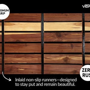 May include: A rectangular wooden bath mat composed of horizontal cedar slats in varying shades of brown and tan, secured by two vertical black non-slip runners. The mat features text labels reading MAXIMUM GRIP, ZERO RUST, VIDA, and Inlaid non-slip runners.