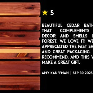 May include: A rectangular cedar bath mat composed of horizontal wooden slats with visible reddish-brown grain patterns. To the right, a yellow star icon, the number 5, and a customer review text: BEAUTIFUL CEDAR BATH MAT THAT COMPLEMENTS OUR DECOR AND SMELLS LIKE A FOREST. WE LOVE IT! WE ALSO APPRECIATED THE FAST SHIPPING AND GREAT PACKAGING. HIGHLY RECOMMEND, AND THIS WOULD MAKE A GREAT GIFT. AMY KAUFFMAN | SEP 30 2025