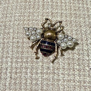 Broche de abeja vintage en tono dorado con perla artificial y cristal rubí.