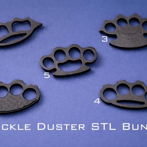 May include: An assortment of five black knuckle dusters, each with a unique design, arranged on a blue surface. The text "KNUCKLE DUSTER STL BUNDLE" is displayed at the bottom. The designs include various shapes and textures.