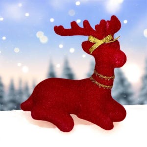May include: A red reindeer figurine with a gold bow and necklace. The reindeer is posed on a snowy surface with a wintery background. The figurine is a festive holiday decoration.