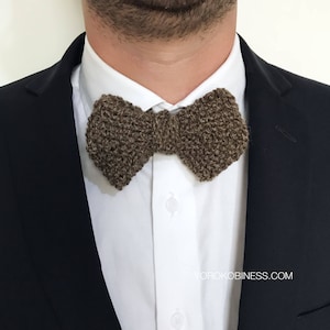 May include: A brown knitted bow tie. The bow tie is made of a textured yarn and has a slightly distressed look.