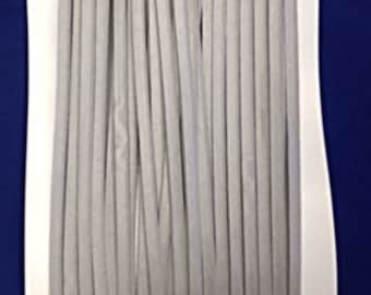 May include: A bundle of gray suede leather cord, approximately 25 strands, arranged in a parallel pattern on a white background.