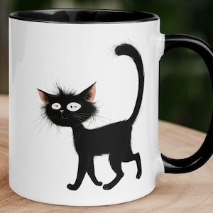 May include: White ceramic mug with a black interior, handle, and a whimsical black cat illustration. The cat has a fluffy appearance with pink-tipped ears and a long, curved tail. The mug is designed for hot beverages.