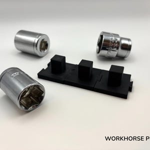 May include: Image of three chrome sockets and a black socket organizer. The sockets are cylindrical with a hexagonal opening. The organizer is rectangular with three raised square posts. The text "WORKHORSE PRINTS" is at the bottom.