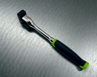 May include: A 3/8-inch drive ratchet wrench with a black and green handle. The wrench has a chrome finish on the head and shaft. The handle is black with a green accent near the base.