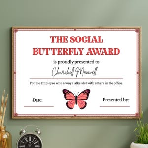 May include: A framed certificate with the text "THE SOCIAL BUTTERFLY AWARD" in red. The certificate is presented to "Churchill Maxwell" and features a butterfly illustration. The text reads "For the Employee who always talks a lot with others in the office."