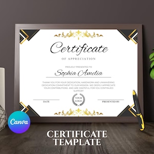 May include: A framed certificate template with a brown border. The certificate features gold and black decorative elements, with the words "Certificate of Appreciation" at the top. The text "Sophia Amelia" is prominently displayed. A pen rests on the frame.