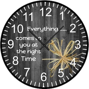 May include: A black and white clock with a wood grain background. The clock face has white numbers and hands. The clock has a quote that reads "Everything comes to you at the right time".