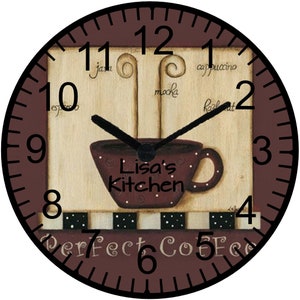 May include: A brown and white kitchen clock with black hands. The clock face features a coffee cup with steam rising from it and the text "Lisa's Kitchen" and "Perfect Coffee".